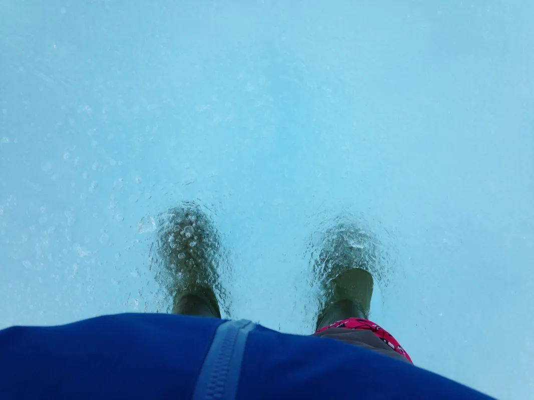 Photo of NASA researcher Walt Meier's boots in a melt pond